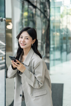 Beautiful business woman using mobile phone work in business buildings. Smart female using cell phone chatting for business communication talking. Business lifestyle concept.