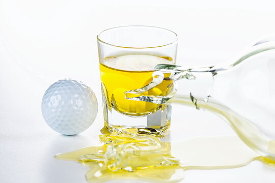 Bicchiere di Whisky con pallina da golf dopo una sconfitta a fine partita 