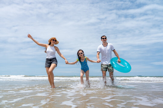 A cheerful family splashes through shallow seawater embracing outdoor fun healthy living and meaningful moments during a sunny coastal vacation
