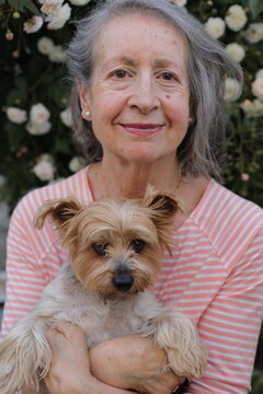 A cute senior woman and her lap dog