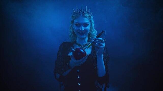 woman dark queen fairytale witch character, in process of poisoning apple. Gothic fantasy evil girl smiling face holding syringe with green poison. enchanted apple for princess. dark night moon light