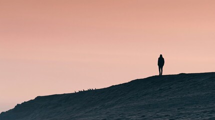 Fototapeta premium Silhouetted Figure Standing on High Ridge at Sunset