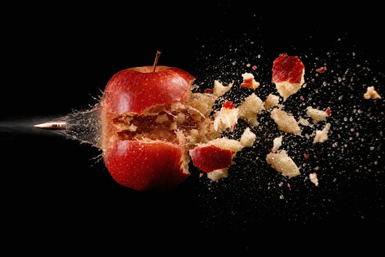 Exploding red apple pierced in dramatic slow motion