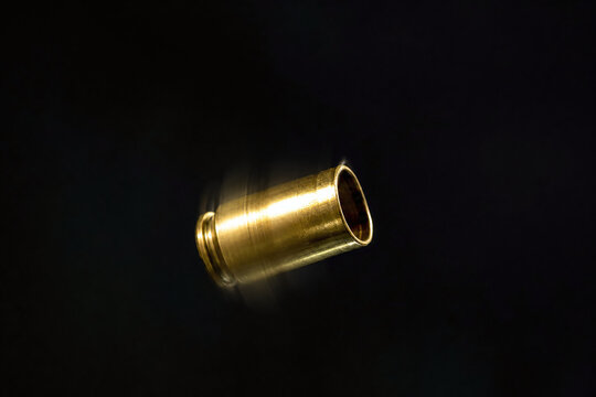 Spinning brass shell casing in dramatic dark macro
