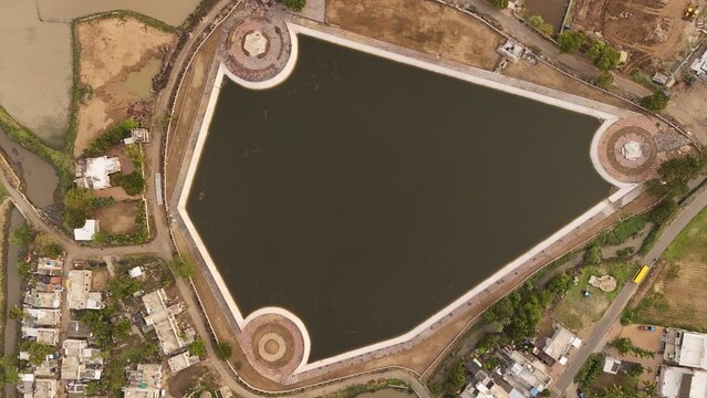 Top Down Aerial Drone View of Urban Lake Reservoir with Geometric Embankment and Surrounding Residential Area