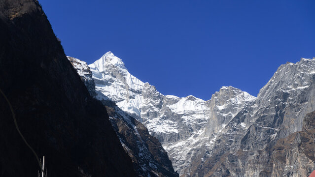 Neelkanth Parvat, Himalayas, snow-covered peak under clear blue sky with sunlight shining brightly on the mountain range