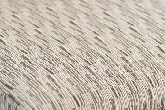Close-up of beige and grey woven fabric texture background.