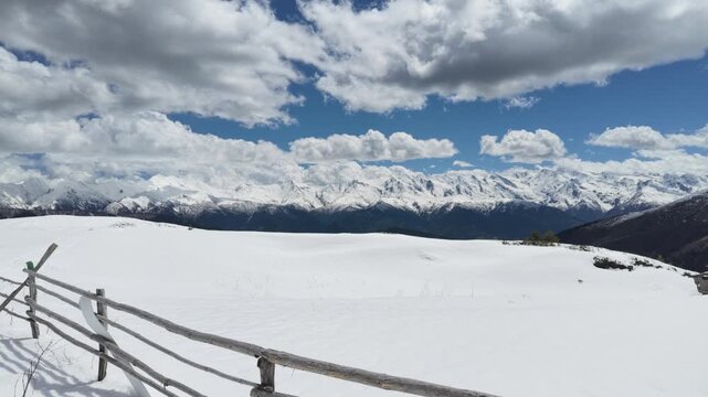 Snowy Koruldi ridge landscape in Svaneti Georgia with wooden fence and majestic Caucasus mountains, winter travel destination