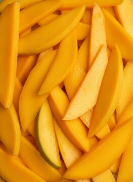 Top view close up of fresh ripe yellow mango slices background