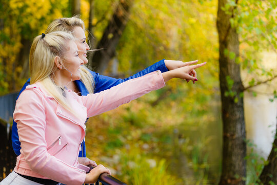 Two women walking in autumn park