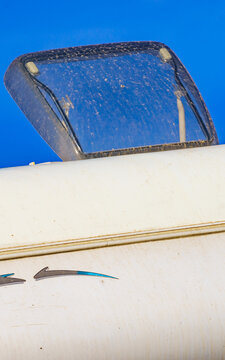 Sunroof, raisable window on roof top of camper vehicle against blue sky