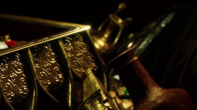 A treasure chest is open and shows various colorful trinkets and artifacts inside. The setting has a dark background with slight reflections from the metal. The objects create intrigue and curiosity.