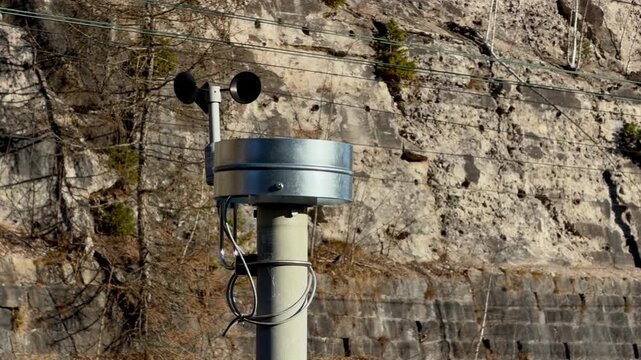 Anemometer measuring wind speed on a high mountain road, reflecting scientific monitoring for weather forecasting and safety in hazardous alpine terrain during a sunny winter day