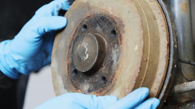 Old rusty car brake drum, repair in workshop.