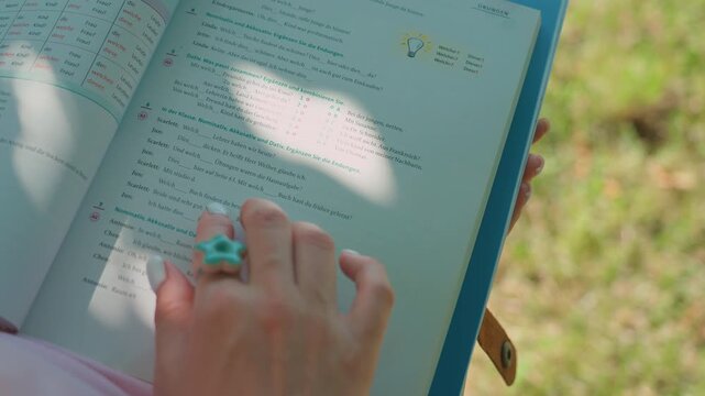 German language textbook with hand pointing at grammar exercises