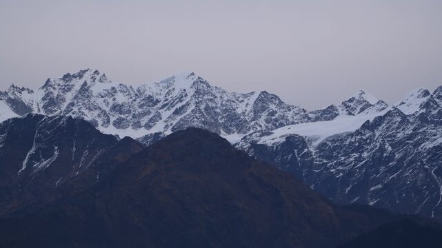 Telephoto Panning Shot Over Dark Ridges And Snowy Mountain Range India