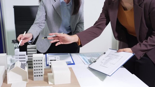 Engineering team collaborates on blueprint and project planning. Strategic partnership and innovation drive successful model development in a corporate office.