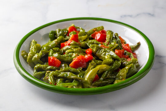 Roasted green friggitello peppers and diced tomatoes served - Turkish name; Biber kizartmasi
