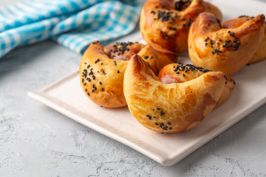 Freshly baked Turkish ay coregi crescent pastry with chocolate filling and black cumin seeds on plate