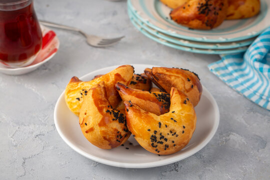 Freshly baked Turkish ay coregi crescent pastry with chocolate filling and black cumin seeds on plate