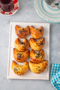 Freshly baked Turkish ay coregi crescent pastry with chocolate filling and black cumin seeds on plate