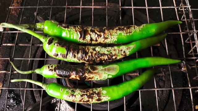 Grilling chili pepper on stove, indoor Chiangmai Thailand.
