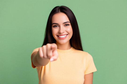 Cheerful Young Woman Pointing Finger Forward with Bright Smile and Confident Gesture