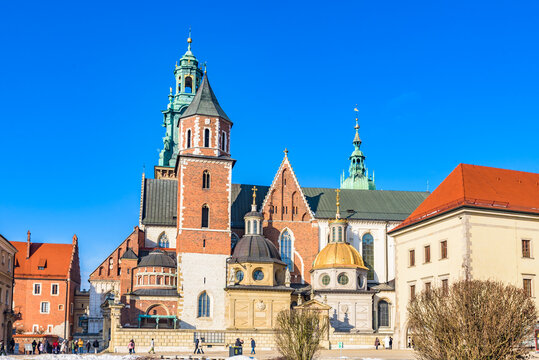 Exterior view of Wawel Cathedral with its iconic golden Sigismund Chapel under a blue sky, a UNESCO World Heritage Site.