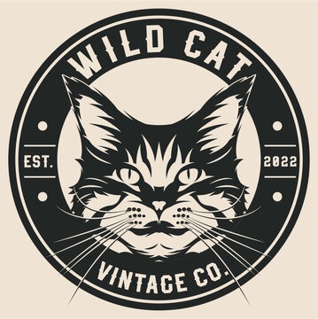Vintage style black and cream cat face logo with whiskers in a circular badge with western serif font text Wild Cat and Vintage Co.