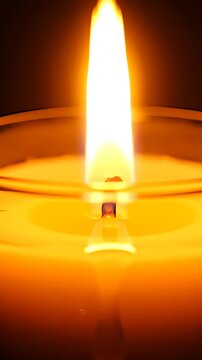 Burning candle flame close up with warm glow