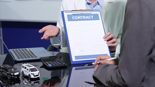 Asian woman uses a calculator to estimate car loan monthly payment, planning budget, finance, credit, and vehicle insurance.