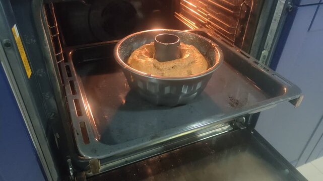 Freshly baked bundt cake cooking in hot oven