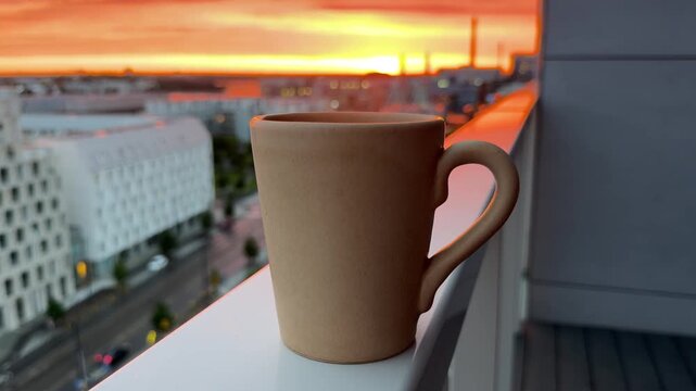 Steaming cup on Balcony Railing at Urban Helsinki Sunset