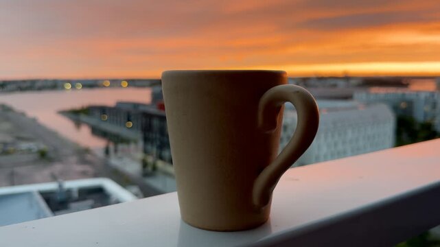 Close-up of Mug Against Glowing Sunset Sky on Balcony