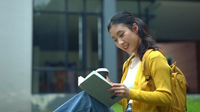 Happy Asian University Student Reading Book with Coffee Outdoors on Campus