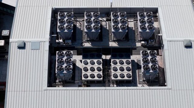 Close up aerial view of rooftop AI data center ventilation fans spinning for cooling and HVAC