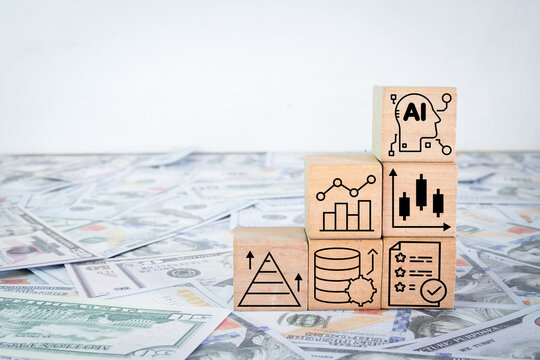 AI in finance and investment growth concept. Wooden blocks with artificial intelligence and financial chart icons stacked on US dollar bills. Fintech, algorithmic trading, and data strategy.