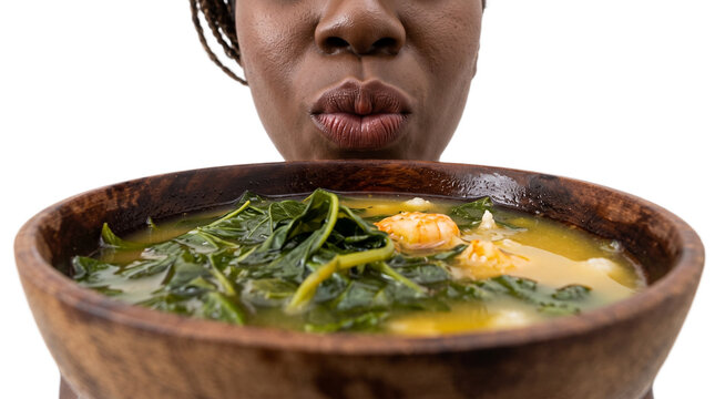 Child eating homemade vegetable soup from wooden bowl. Toddler tasting nutritious spinach and corn broth in rustic kitchenware.