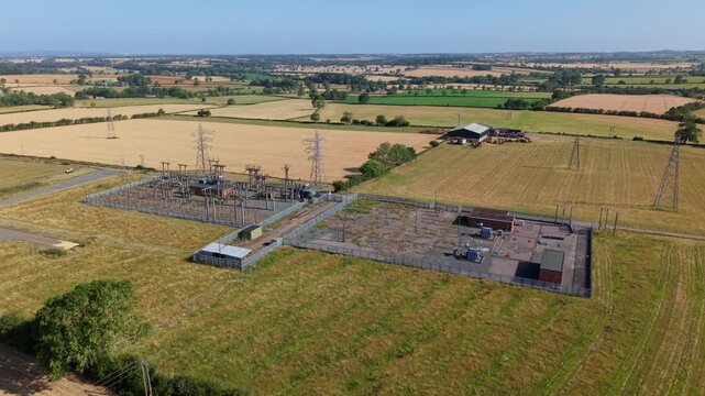 Close up aerial view of small electrical substation transformers and high voltage pylons