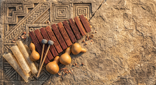 Creative top view of Mexican Marimba de Tecomate mallets on Zapotec carved stone