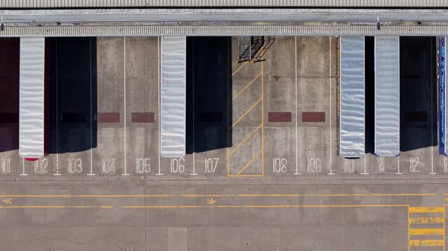 Top-Down Aerial View of Rows of HGV Semi-Trailers Docked in Loading Bays at Logistics Depot