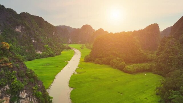 Aerial view of Tam Coc landscape with limestone mountains, river and rice field on Ngo Dong stream, Ninh Binh province, Vietnam