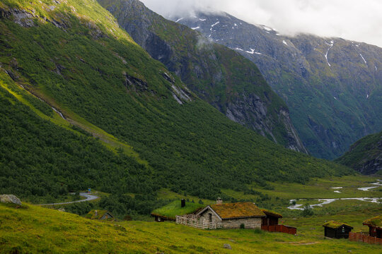 Traditional Norwegian mountain cabins with grass roofs in a scenic valley