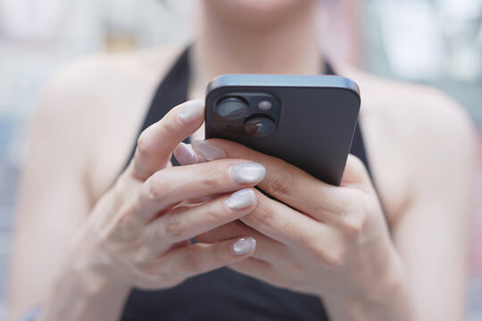 woman holds smart phone in her hands and scrolls through the news feed. Close up of hand uses mobile. point finger on screen, texting text message.