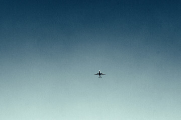 Airplane flying in clear blue sky, minimal minimalist aviation travel theme © Lala Wu