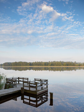 Small pier on a lake shore. Finnish relaxation moment during the holidays. Sunny and calm weather. Place for swimming and fishing.