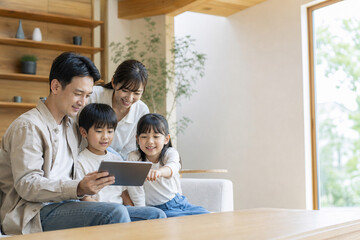 Fototapeta premium Japanese Family Using a Tablet Together in a Bright Modern Home