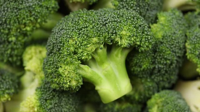 Pile of fresh chopped broccoli florets rotating. Top view shot