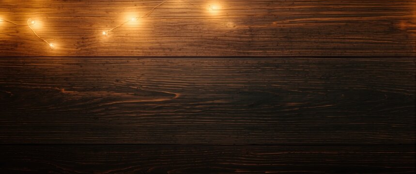 Warm string lights on a dark wooden background