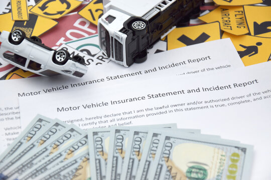 Car insurance policy document and toy cars on desk. Concept of insurance policy and car accident